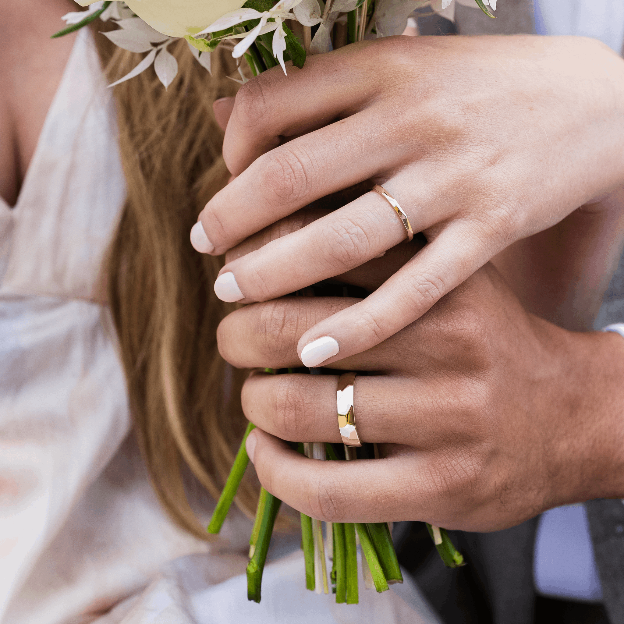 Facets recycled yellow gold Unique contemporary his and hers wedding rings holding a bouquet of flowers by Bespoke Jewellery Designer Emma Hedley Claire Collinson Photography