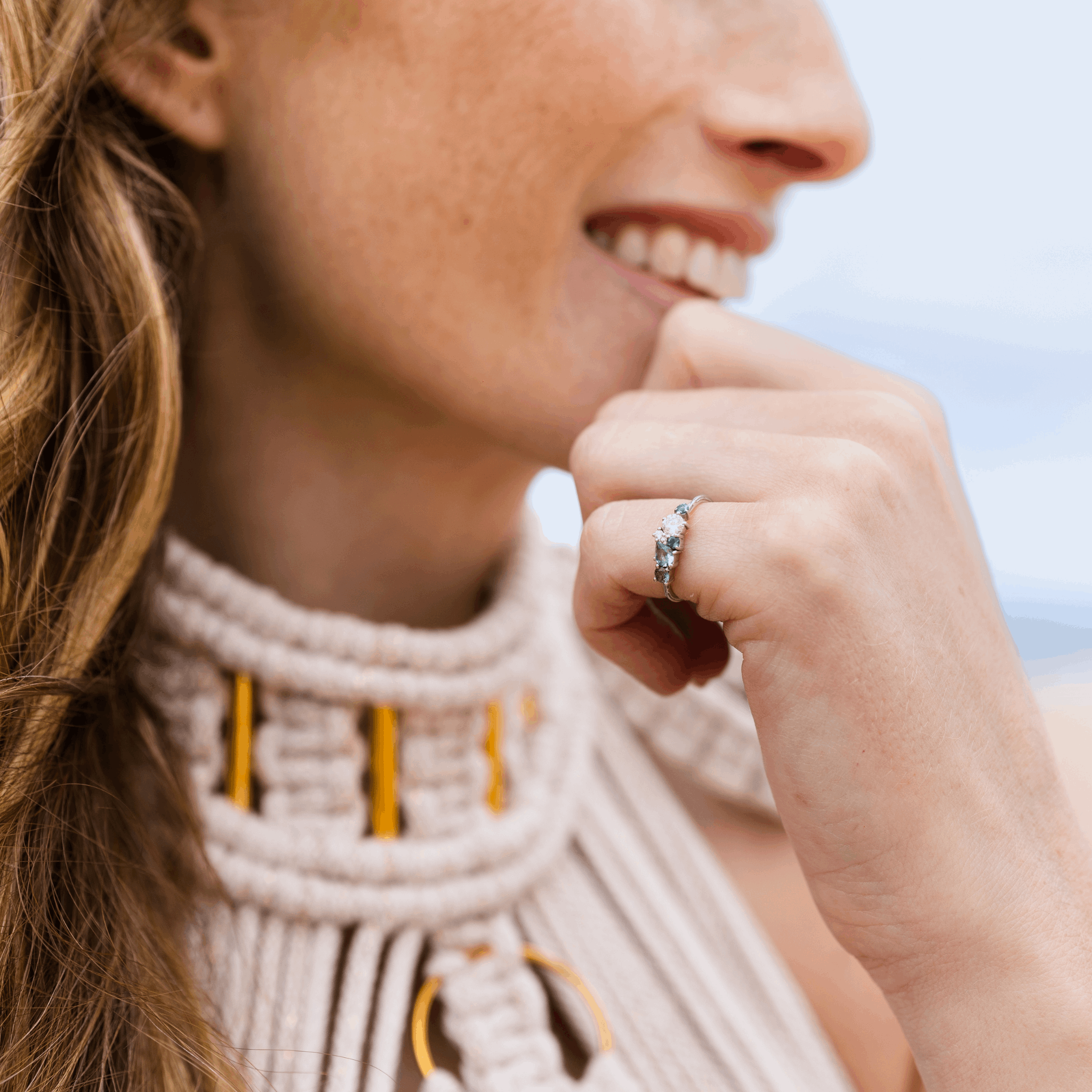 Ocean organic constellation ring blue green sapphire tourmaline cluster 6 stone white gold organic textured band engagement ring worn as a pinky ring by a woman smiling Claire Collinson Photography Emma Hedley fine Jewellery Ethically made