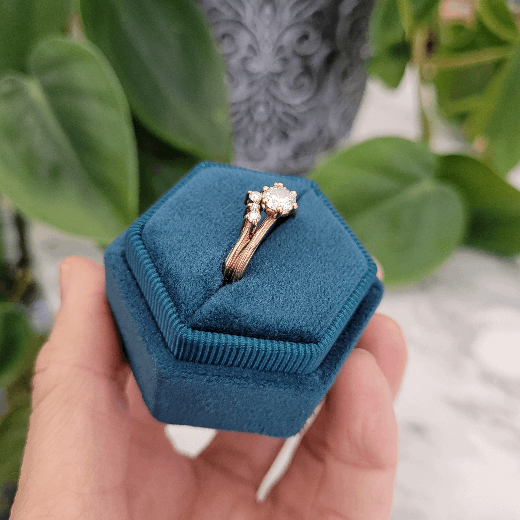 side view 18ct yellow recycled gold natural diamond solitaire with shaped 5 stone wedding ring in teal velvet ring box