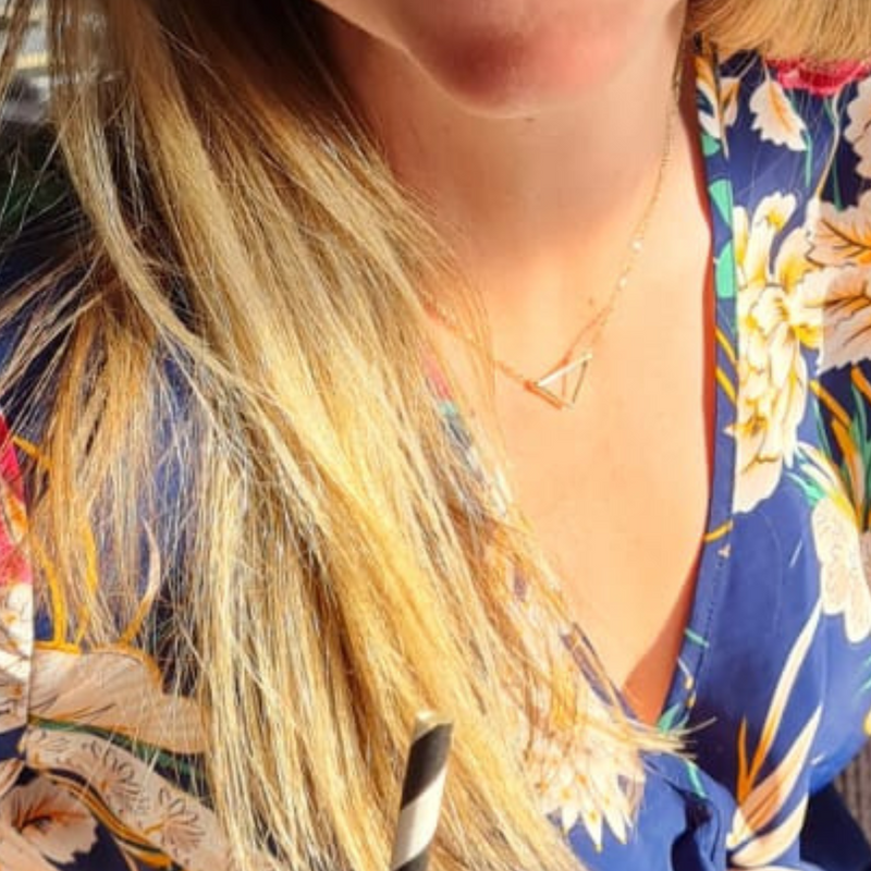9ct yellow gold triangle pendant outline shape necklace by Emma Hedley Jewellery  worn with a flowery dress in the sunshine ready to ship gifts