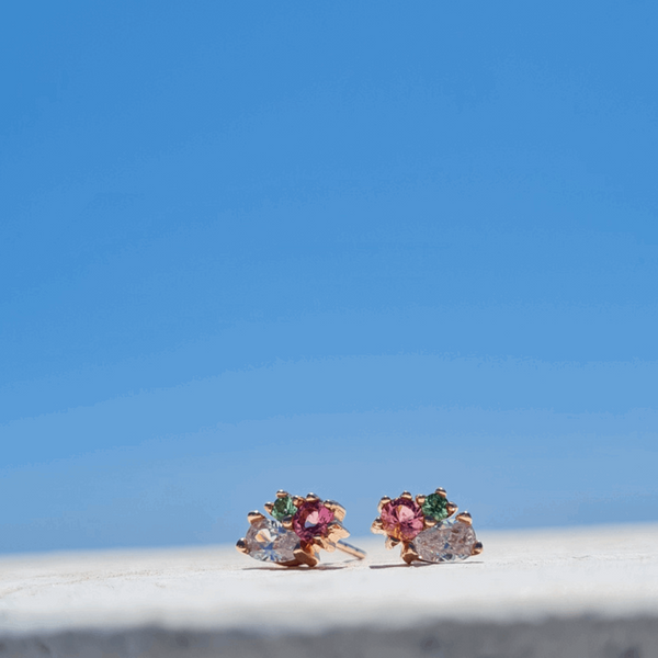 18ct recycled rose gold pink and green tourmaline pear lab grown diamond cluster stud earrings against a colourful blue sky exquisite gemstone jewellery by Emma Hedley