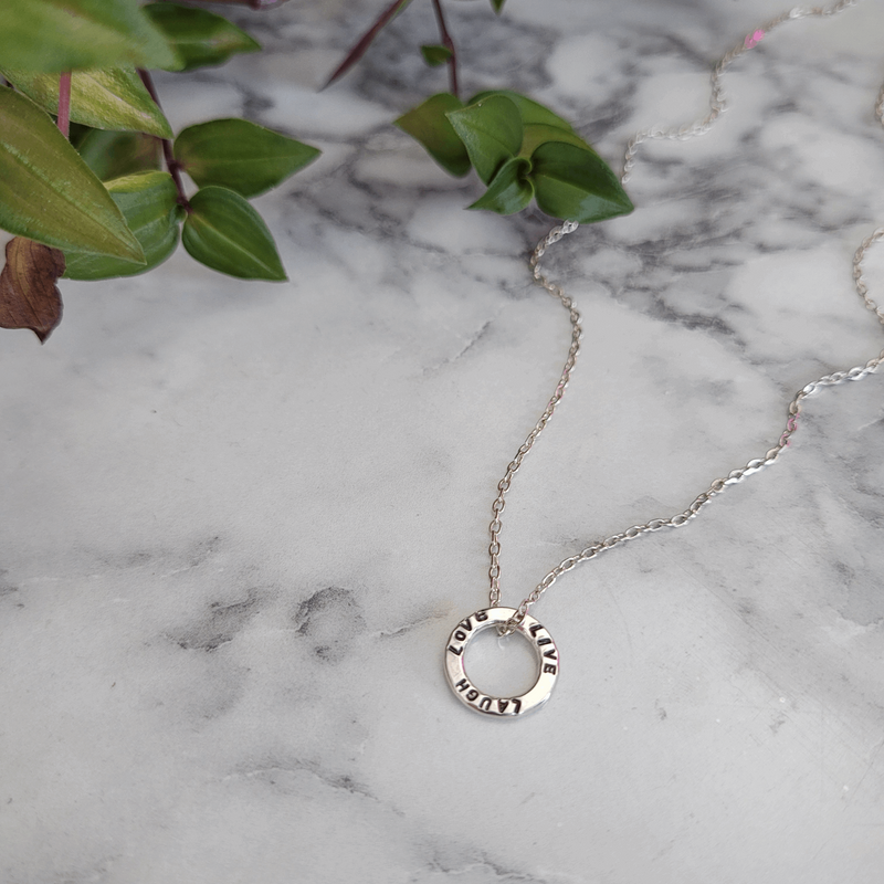 Dainty Hoop Personalised Pendant hand stamped with custom message on a trace chain. Laid on a white marble background. Handmade by Emma Hedley Jewellery Desinger