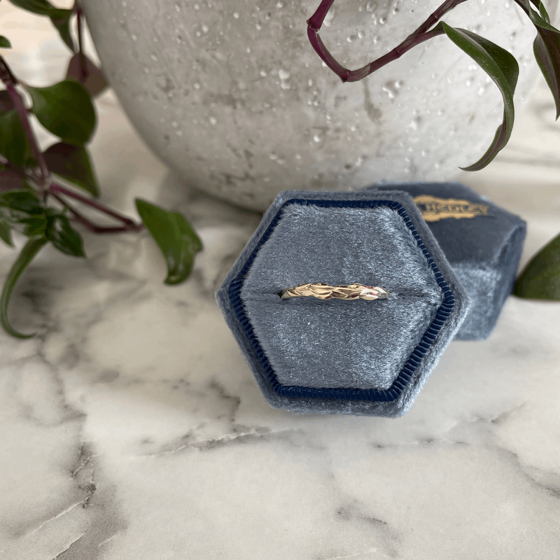 Forest leaf detail textured unique alternative wedding ring by fine custom jeweller Emma Hedley in a vintage blue hexagon velvet ring box